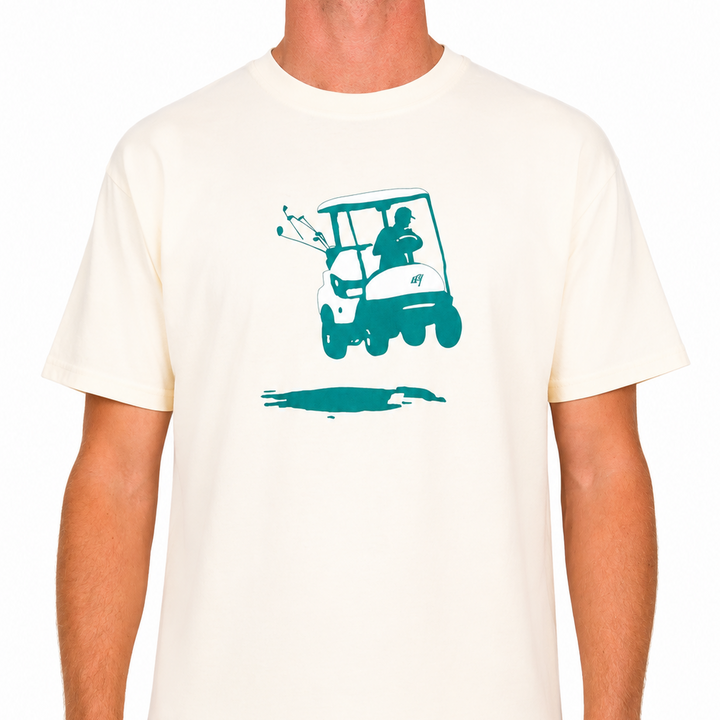 Male model wearing an off-white Sandtrap T-shirt featuring a teal golf cart graphic centered on the chest. Shown from the front against a clean studio background.