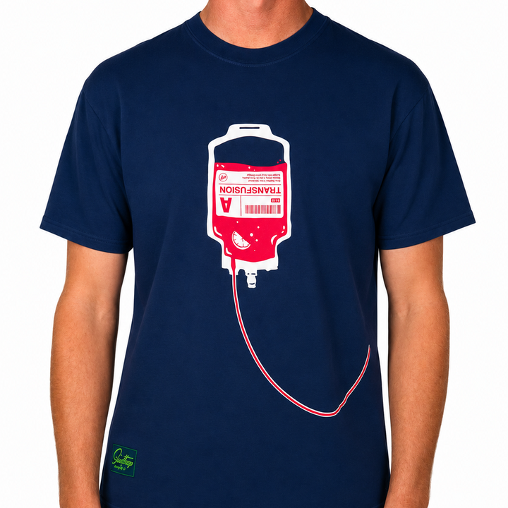 Front view of a male model wearing a navy blue graphic t-shirt against a clean white studio background. The t-shirt features a large red, white, and pink transfusion IV bag graphic centered on the chest with tubing extending across the lower front.